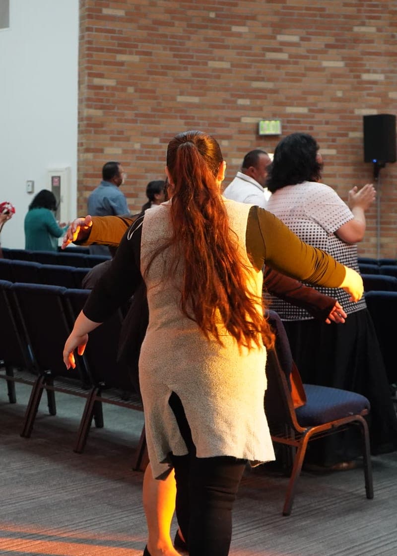 Adoración con los brazos abiertos entre las filas